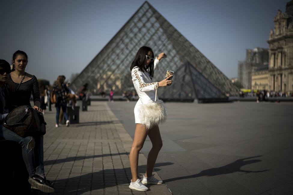 Une touriste prend un selfie devant le musée du Louvre, le 16 octobre 2017 à Paris.