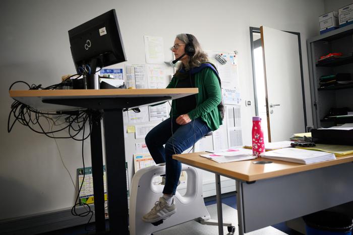Une secrétaire du lycée Anita-Conti pédale sur un vélo d’appartement tout en travaillant à son bureau, dans le cadre d’un programme de lutte contre l’obésité et la sédentarité, à Bruz, dans l’ouest de la France, le 17 mars 2025. (Image d'illustration)
