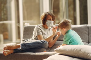 Une mère donne un médicament à son fils touché par un rhume. 