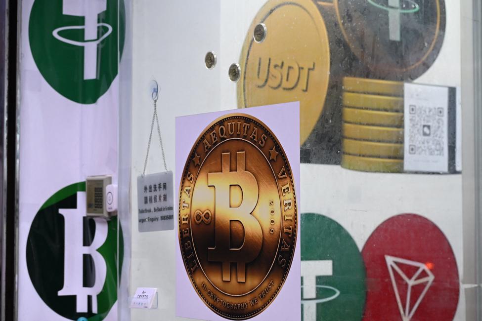 Les symboles du bitcoin et du stablecoin Tether (USDT) sont exposés dans une boutique de cryptomonnaies à Hong Kong, le 29 juillet 2025.