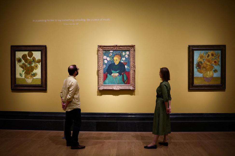 Des visiteurs regardent trois tableaux réalisés par Vincent Van Gogh, lors d'une avant-première presse pour l'exposition « Van Gogh : Poètes et amants » à la National Gallery, à Londres, le 9 septembre 2024.