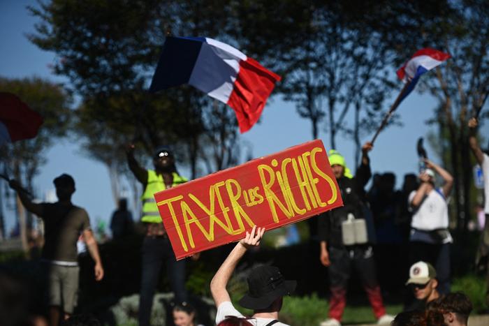 Des manifestants brandissent des drapeaux nationaux français et un slogan sur lequel on peut lire « Taxer les riches » à Bordeaux, le 18 septembre 2025.