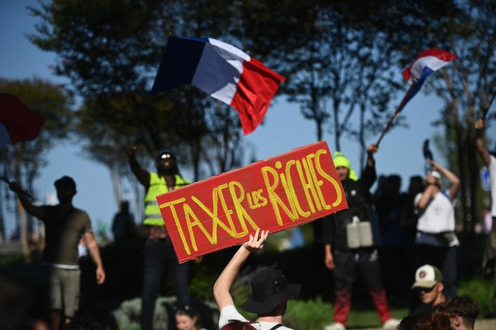 Des manifestants brandissent des drapeaux nationaux français et un slogan sur lequel on peut lire « Taxer les riches » à Bordeaux, le 18 septembre 2025.