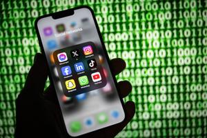 Une personne consulte son téléphone qui affiche le logo de nombreux réseaux sociaux.