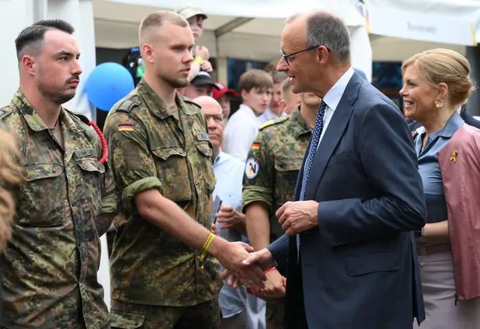 Le chancelier allemand Friedrich Merz et la présidente du Bundestag (chambre basse du Parlement) Julia Klöckner serrent la main à des soldats de la Bundeswehr lors d'une cérémonie commémorant la Journée nationale des anciens combattants, le 21 juin 2026 à Berlin.