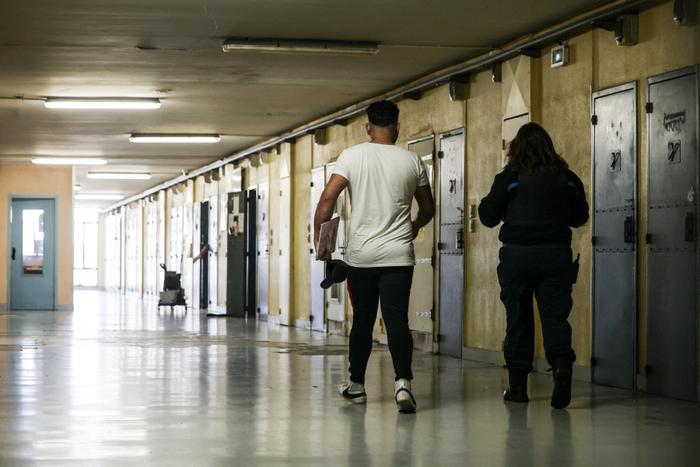 Un détenu et un gardien de prison marchent dans un couloir de la prison de Gradignan, près de Bordeaux, dans le sud-ouest de la France, le 3 octobre 2022.