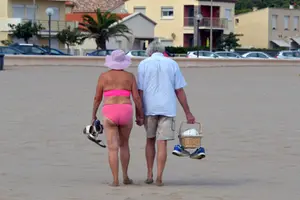Un couple de personnes âgées se promène sur la plage de Narbonne-Plage, dans le sud-ouest de la France.