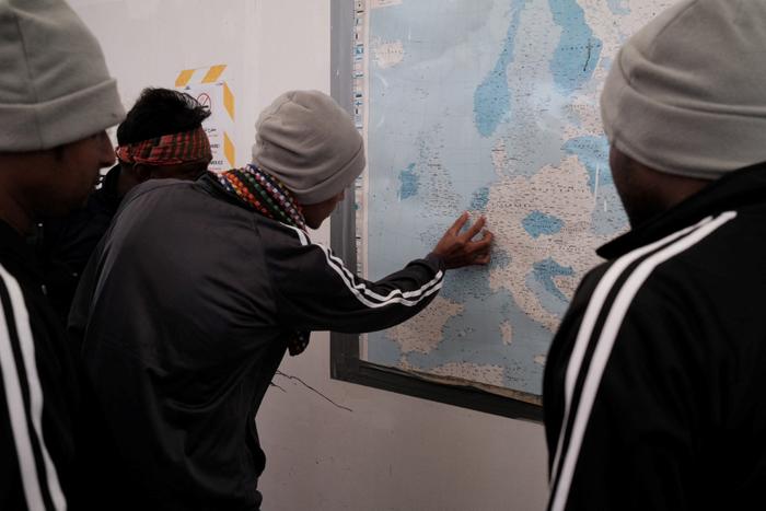 Des migrants du Bangladesh regardent une carte de l'Europe à bord du navire de sauvetage Ocean Viking de l'organisation humanitaire maritime européenne "SOS Méditerranée" après une opération de sauvetage au large de Malte, le 22 mai 2024.