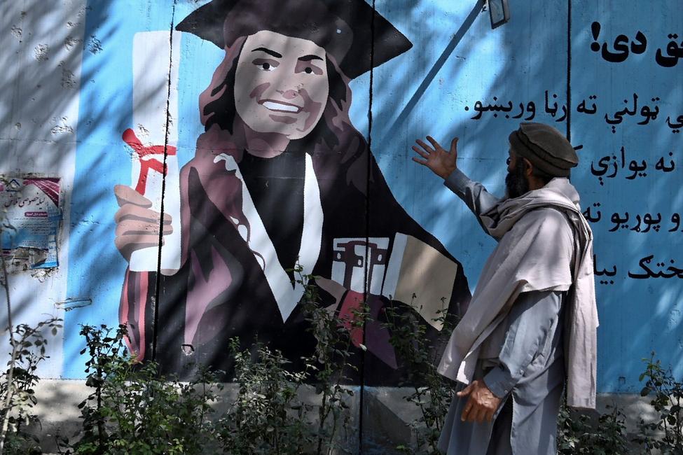 Un Afghanistan montrant une peinture murale d'une étudiante.