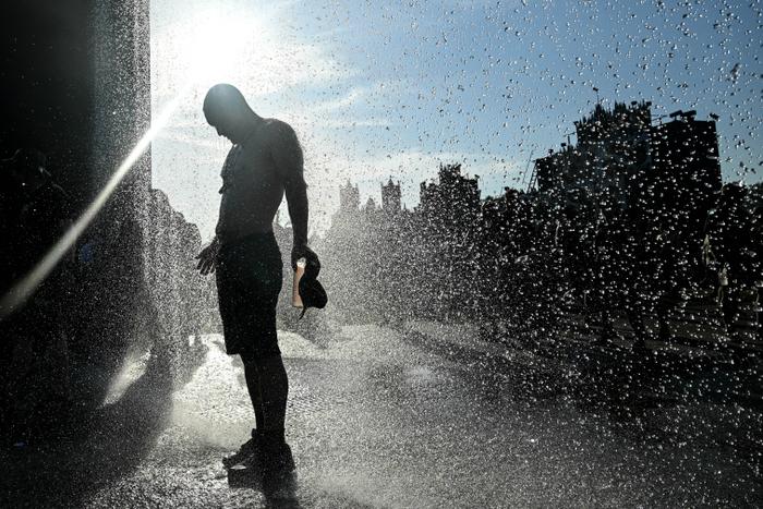 Un festivalier se rafraîchit sous un rideau d’eau lors de la 18e édition du festival Hellfest, dédié au rock et au métal, à Clisson, dans l’ouest de la France, le 19 juin 2025, alors qu’une vague de chaleur frappe le pays.