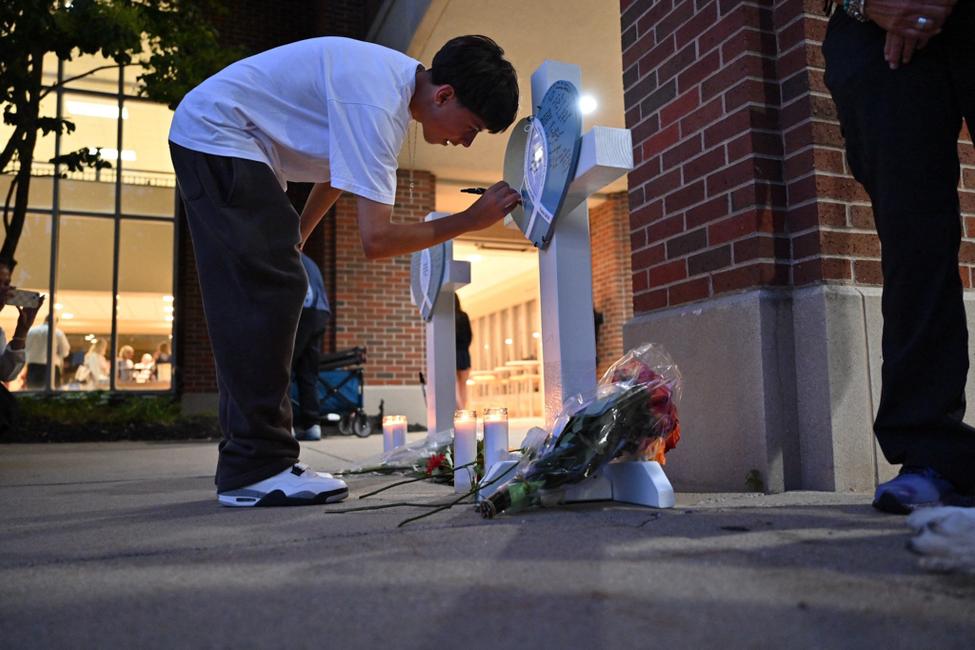 Un élève de l'école touchée se rend sur le mémorial participatif organisé à la suite de la fusillade dans une église rattaché à un établissement scolaire, à MInneapolis le 27 août 2025 (Photo by TOM BAKER / AFP)