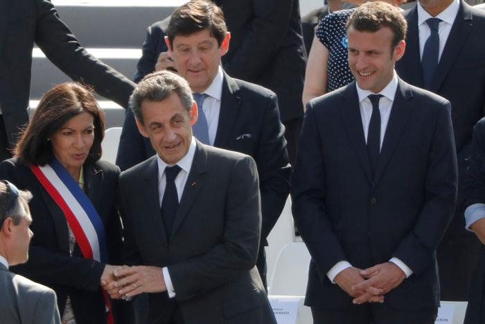 L'ancien président Nicolas Sarkozy, entouré de la maire de Paris Anne Hidalgo (à g.), du ministre des Sports Patrick Kanner (derrière) et du ministre de l'Economie Emmanuel  Macron (à d.) à Paris lors des cérémonies du 8 mai 1945, le 8 mai 2016.