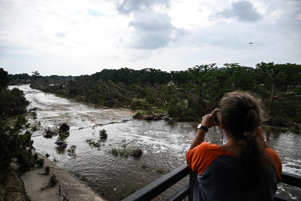 Une habitante observe la rivière Guadalupe en pleine inondations au Texas le 6 juillet 2025 (Photo by RONALDO SCHEMIDT / AFP)