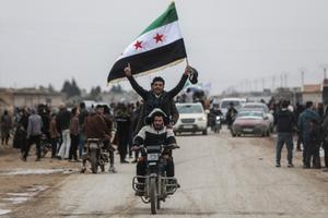 Des hommes à moto agitent un drapeau syrien à trois étoiles tandis que les forces gouvernementales syriennes entrent dans la ville de Qamishli, le 3 février 2026.