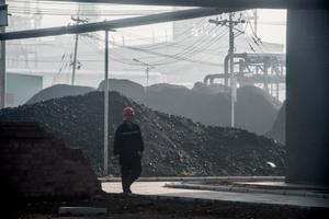 Un ouvrier passe devant l'entrée principale d'une centrale de transformation du charbon en pétrole à Changzhi, dans la province du Shanxi, le 9 novembre 2015.