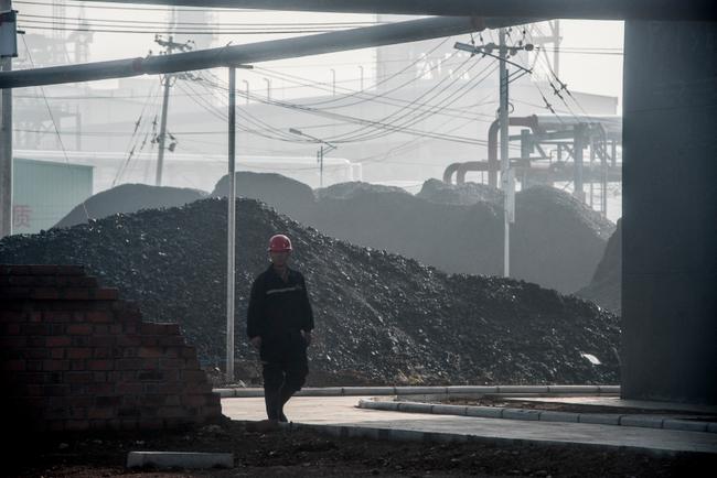 Un ouvrier passe devant l'entrée principale d'une centrale de transformation du charbon en pétrole à Changzhi, dans la province du Shanxi, le 9 novembre 2015.