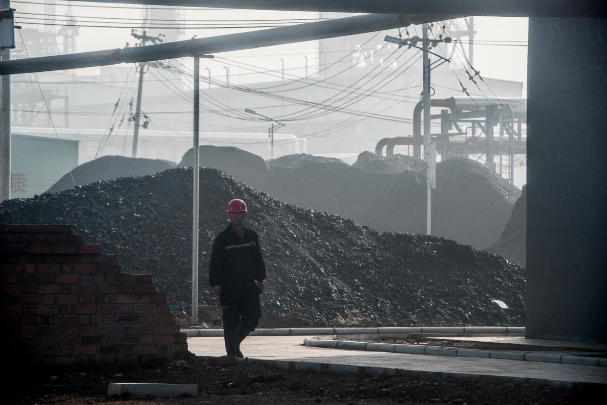 Un ouvrier passe devant l'entrée principale d'une centrale de transformation du charbon en pétrole à Changzhi, dans la province du Shanxi, le 9 novembre 2015.