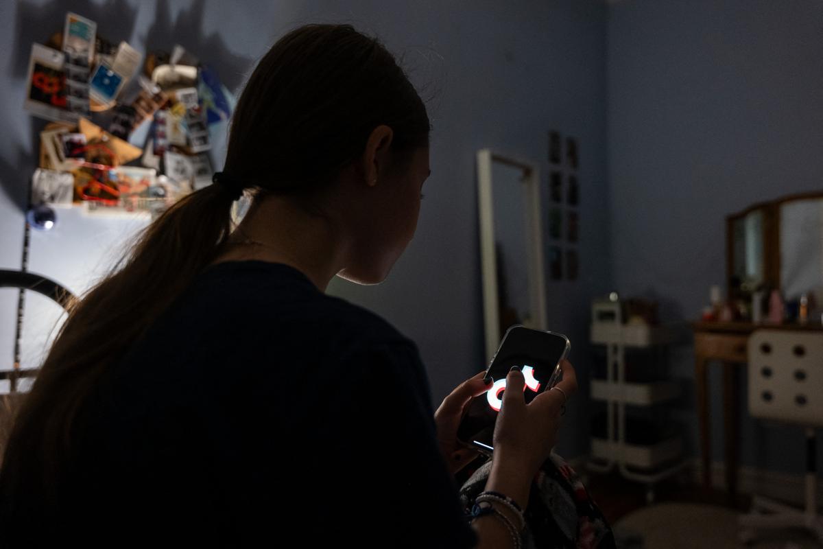 Une adolescente utilise son téléphone portable pour accéder aux réseaux sociaux.