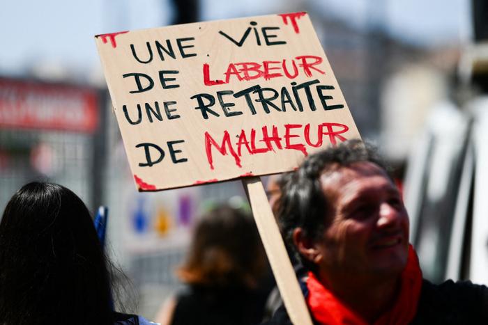 Un manifestant tient une banderole sur laquelle on peut lire « Une vie de labeur, une retraite de malheur » lors d'une manifestation contre la réforme des retraites, à Marseille, le 6 juin 2023.