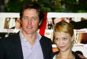 L’acteur britannique Hugh Grant (à gauche) et l’actrice allemande Heike Makatsch sourient en posant lors d’un photocall destiné à promouvoir le nouveau film Love Actually, du réalisateur Richard Curtis, dans un hôtel de Rome, le 28 octobre 2003. (Image d'illustration)