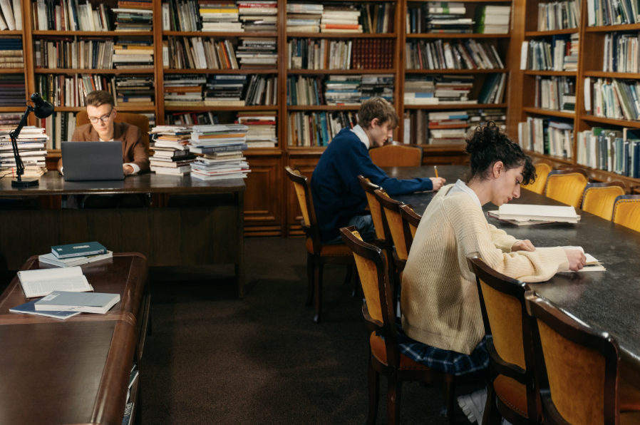 Des étudiants et des doctorants dans une bibliothèque en train de préparer leurs travaux de recherche. 