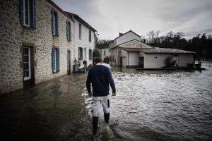 Un homme marche dans une rue inondée de Saint-Laurent-sur-Sèvre, après la crue de la rivière Sèvre-Nantaise due aux fortes pluies.