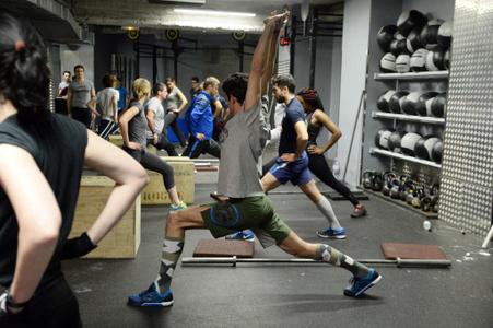 Des personnes en pleine séance de gymnastique dans une salle de sport.