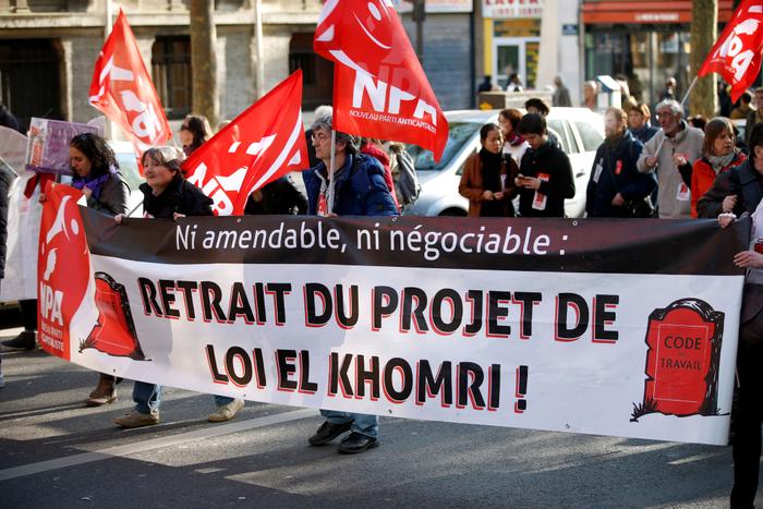 Des militants du Nouveau Parti anticapitaliste (NPA) d'extrême-gauche derruère une banderole "retrait du projet de loi El Khomri" à Paris lors des défilés du 1er mai 2016.