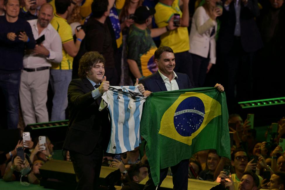 Le président argentin Javier Milei brandit un maillot de l'équipe nationale de football aux côtés de Flavio Bolsonaro, candidat à la présidence brésilienne, qui tient un drapeau national lors du lancement de sa candidature au sein du congrès du Parti libéral, à Sao Paulo, au Brésil, le 25 juillet 2026.