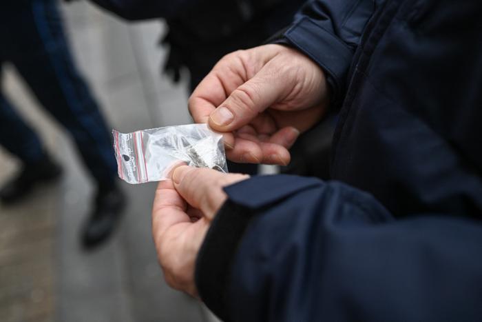Un policier français tient quelques grammes de cannabis lors de la fouille d’un suspect, dans le cadre d’une opération antidrogue. (Image d'illustration)