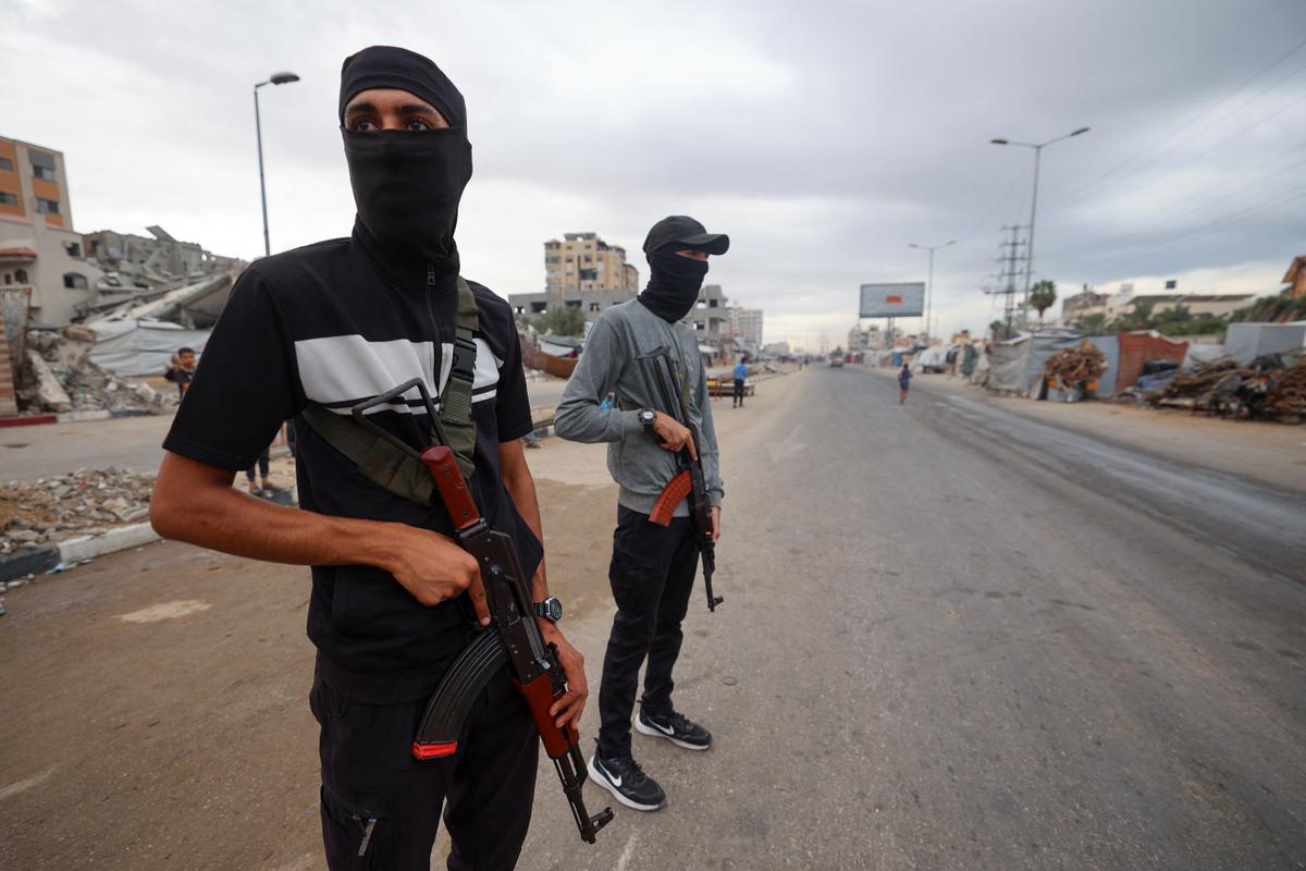 Des membres des forces de sécurité intérieure fidèles au groupe palestinien Hamas, gardent un point de contrôle dans le camp de réfugiés de Nuseirat, dans le centre de la bande de Gaza, le 12 octobre 2025.