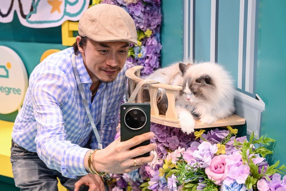 Un visiteur prend un selfie avec un chat lors de l'Exposition féline de Hong Kong.