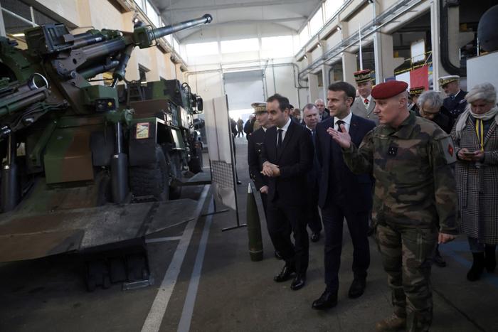 Emmanuel Macron et Sébastien Lecornu examinent un système d'artillerie automoteur "César" lors d'une visite à la base navale de Cherbourg, le 19 janvier 2024.