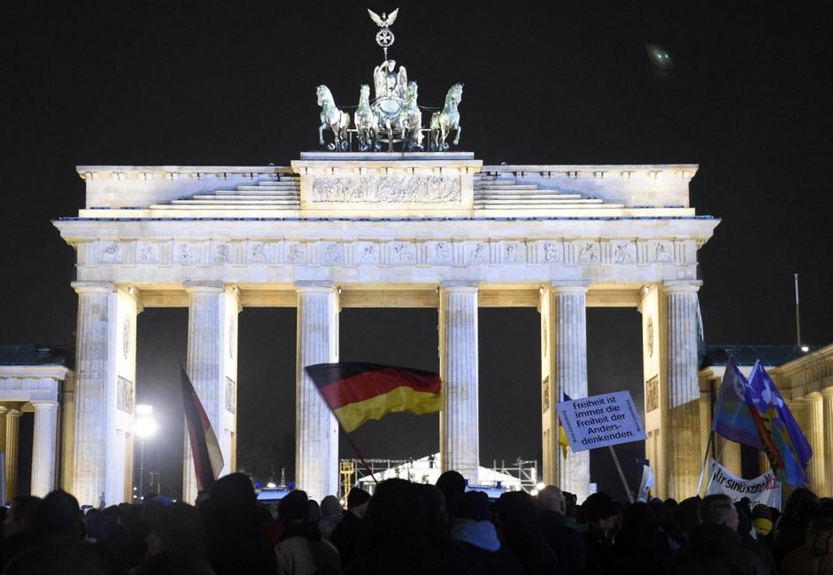 Des personnes brandissant des drapeaux allemands participent à un rassemblement de BERGIDA, une antenne locale du mouvement populiste PEGIDA, près de la porte de Brandebourg à Berlin, dans l'est de l'Allemagne.