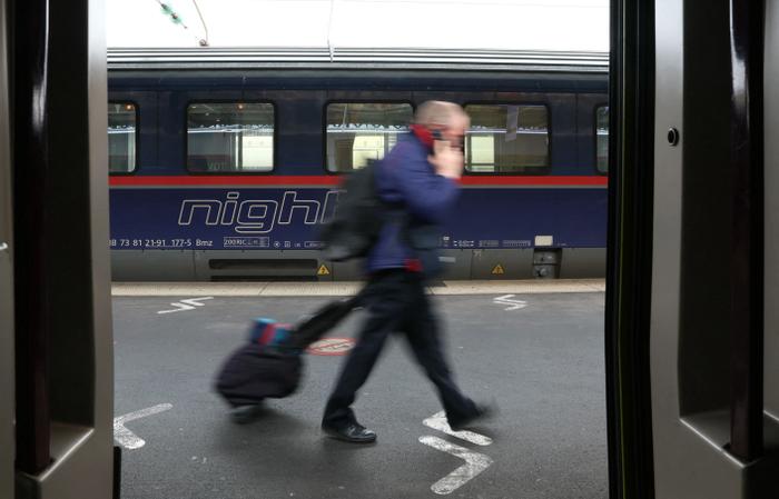 Un employé de la SNCF passe devant un wagon du train Berlin-Paris « nightjet » après son arrivée à la gare de l'Est à Paris, le 12 décembre 2023.