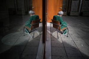 Un patient est assis sur une chaise dans une cour de l'hôpital psychiatrique "EPS de Ville Evrard, Centre psychiatrique du Bois de Bondy", le 7 mai 2020.