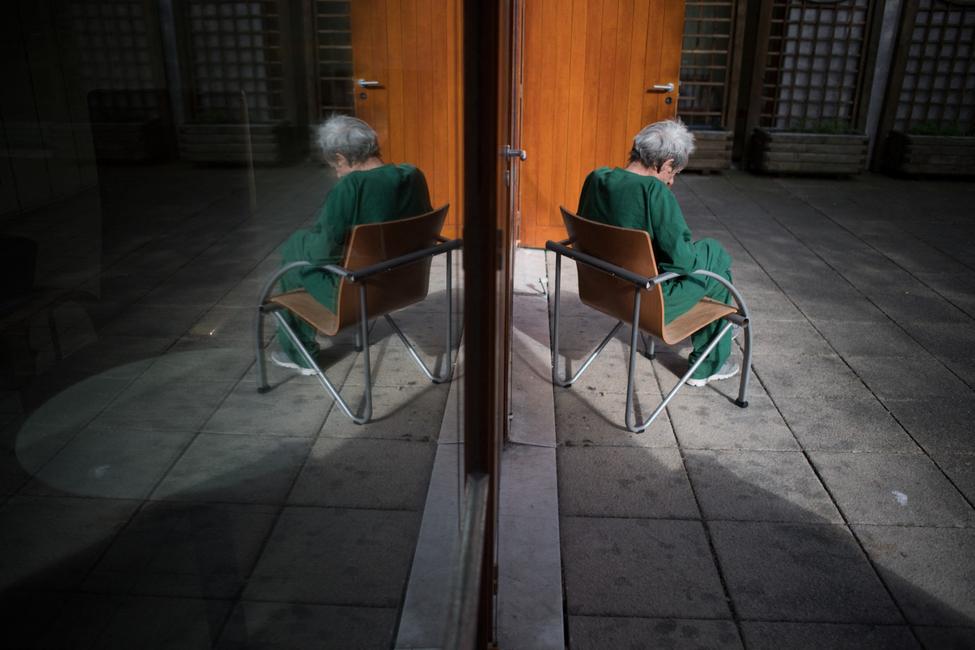 Un patient est assis sur une chaise dans une cour de l'hôpital psychiatrique "EPS de Ville Evrard, Centre psychiatrique du Bois de Bondy", le 7 mai 2020.