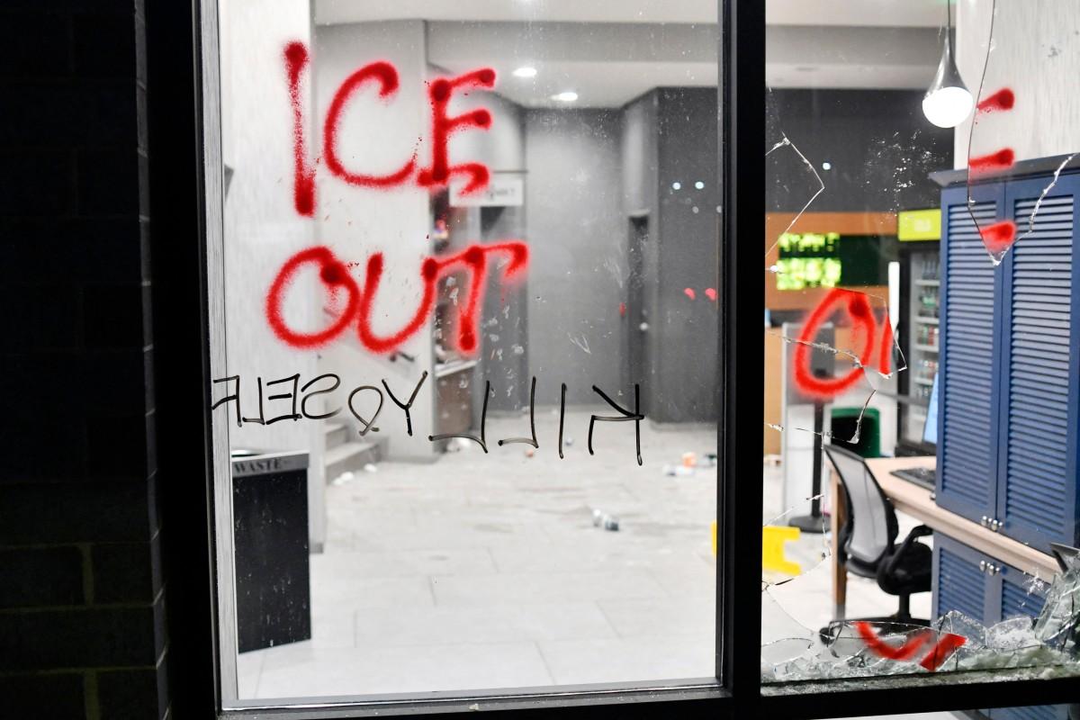 Des graffitis et une vitre brisée sont visibles lors de la manifestation « ICE OUT ! Noise Demo » organisée par des manifestants dans un hôtel de Minneapolis, dans le Minnesota, le 25 janvier 2026.