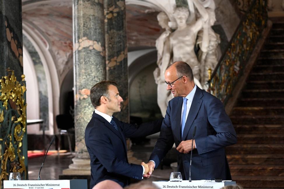 Le président français Emmanuel Macron (à gauche) et le chancelier allemand Friedrich Merz (à droite) se serrent la main après une conférence de presse conjointe au château d'Augustusburg, à Brühl, dans l'ouest de l'Allemagne, le 17 juillet 2026, lors du 26e cabinet franco-allemand.