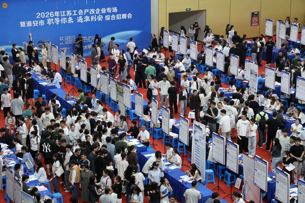 Des demandeurs d'emploi consultent des offres d'emploi lors d'un forum de l'emploi destiné aux jeunes diplômés, organisé au gymnase de l'université de Huai'an, en Chine. 