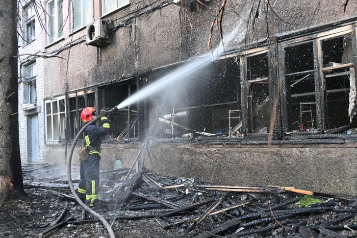 Un pompier éteint un incendie dans un bâtiment endommagé par une frappe de drone russe à Kharkiv, le 11 juin 2025.