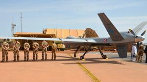 Des membres de l'armée française de l'opération antiterroriste Barkhane dans la région du Sahel en Afrique se tiennent à côté d'un drone Reaper sur la base Barkhane près de Niamey au Niger le 31 juillet 2017 lors de la visite du ministre français des Armées.