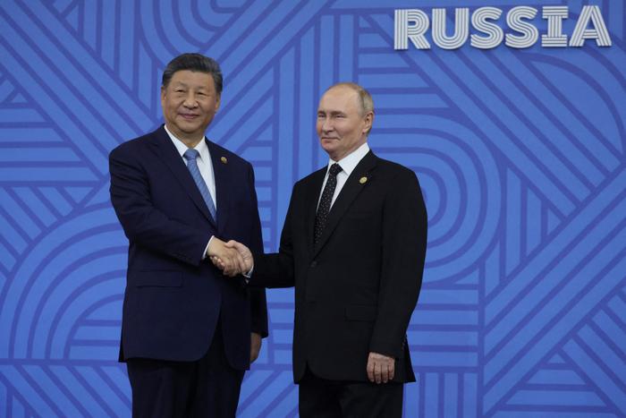 Vladimir Poutine salue le président chinois Xi Jinping lors d'une cérémonie officielle d'accueil des chefs de délégation au sommet des BRICS à Kazan, le 23 octobre 2024.