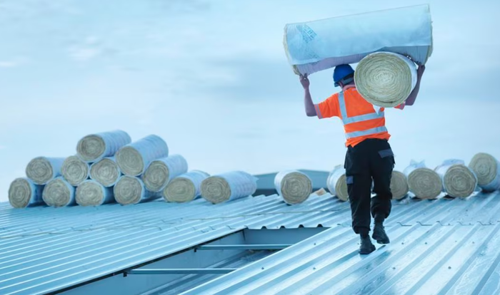 Un ouvrier s'apprête à rénover un bâtiment.