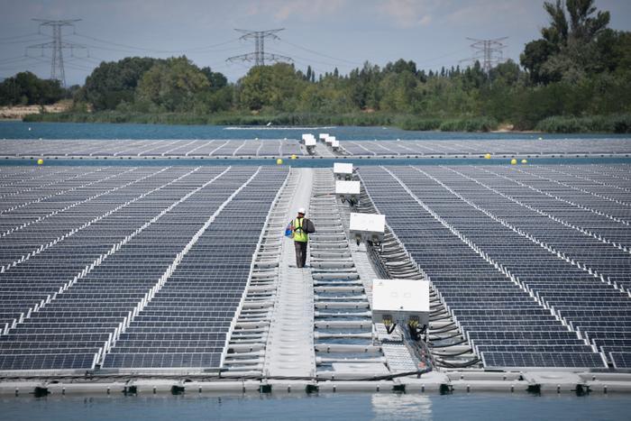 Un technicien marche près des panneaux solaires photovoltaïques de la centrale O'Mega1 à Piolenc, dans le sud de la France, le 30 juillet 2019.