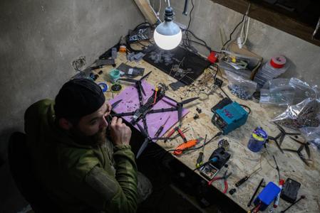Des soldats ukrainiens de l'unité Black Wing, 116e brigade mécanisée, construisent des drones FPV dans un atelier situé près de la ligne de front de l'est de l'Ukraine, le 8 octobre 2025.