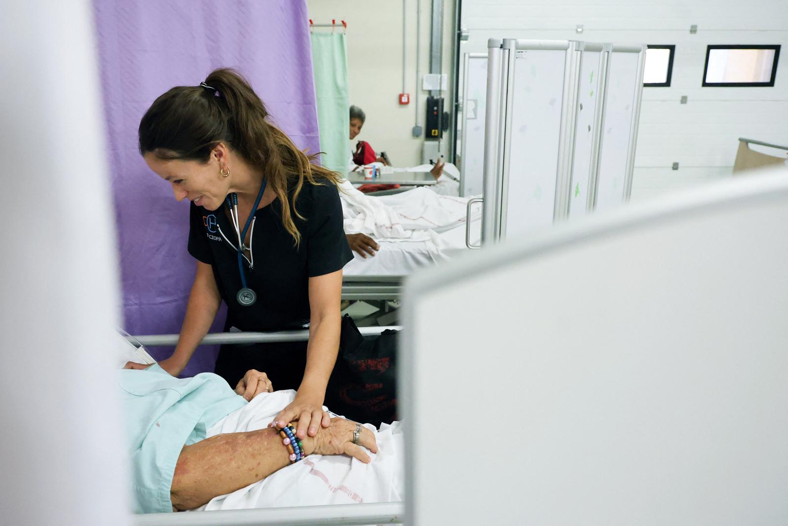 Une membre du personnel soignant assiste un patient atteint de chikungunya au Centre Hospitalier Ouest Réunion Chor (CHOR), à Saint-Paul, sur l'île de La Réunion, le 10 avril 2025.