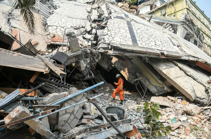 Un secouriste dans les décombres d'un bâtiment détruit, le 29 mars 2025 à Mandalay, en Birmanie.