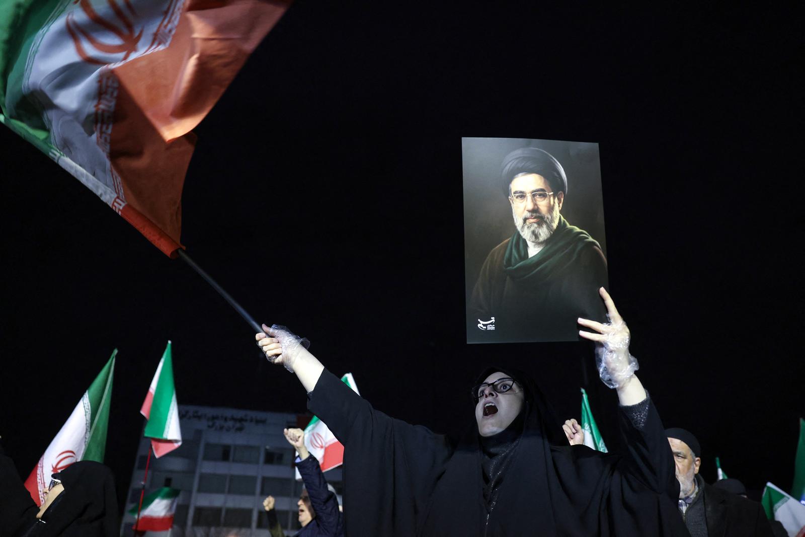 Des personnes agitent des drapeaux nationaux et brandissent des portraits du guide suprême iranien Mojtaba Khamenei lors d’une marche de soutien aux forces armées iraniennes dans le centre de Téhéran, le 25 mars 2026. Le président Donald Trump est prêt à « déchaîner l’enfer » si l’Iran n’accepte pas un accord visant à mettre fin à la guerre au Moyen-Orient, a averti la Maison-Blanche le 25 mars, tout en précisant que les discussions se poursuivaient malgré le rejet, selon certaines informations, d’un plan de paix américain par Téhéran.
