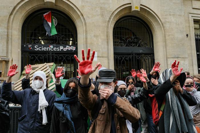Des manifestants lèvent leurs mains enduites de peinture rouge pour symboliser le sang alors qu'ils participent à une manifestation devant l'Institut d'études politiques (Sciences Po Paris) occupé par des étudiants, en soutien aux Palestiniens, à Paris, le 26 avril 2024. (Image d'illustration)